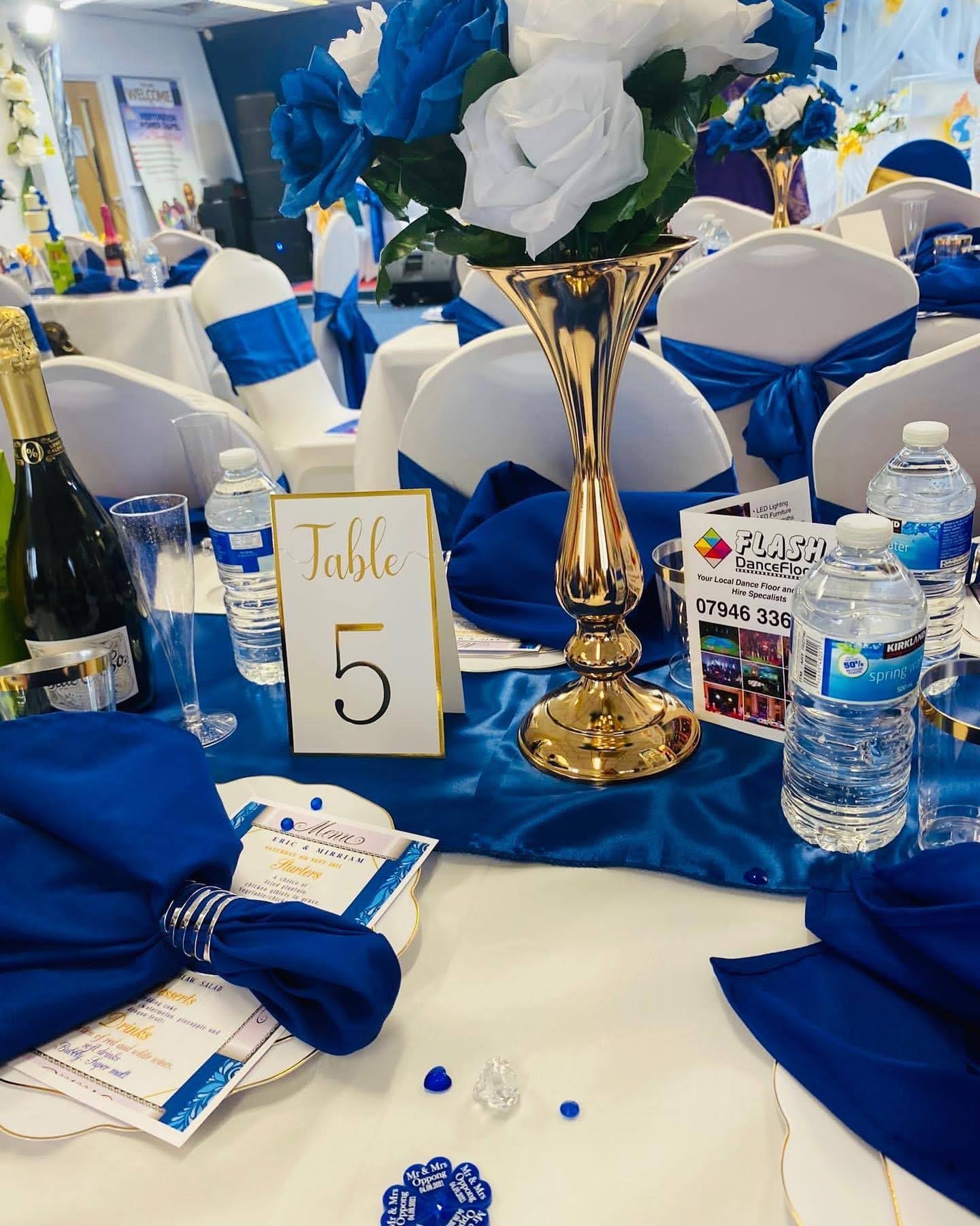 Royal blue and white floral arrangement in a golden decorative vase